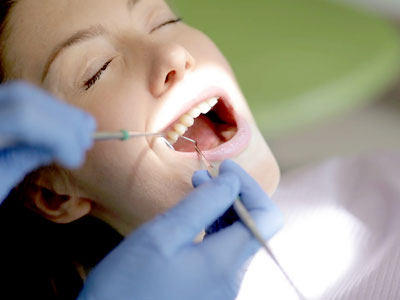 Dentist examining patient’s teeth in Houston dental clinic